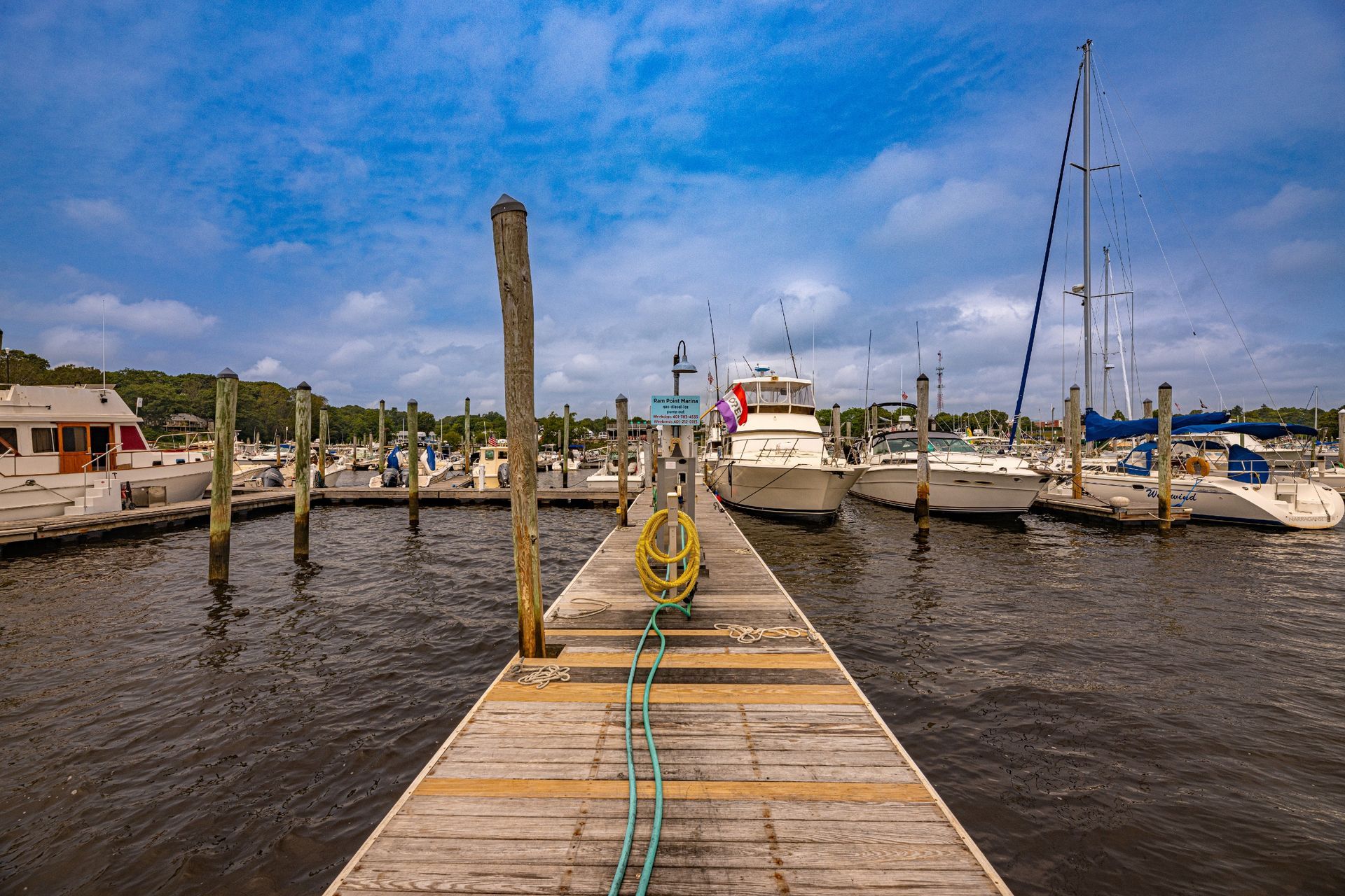 A dock with boats docked at a marina on a sunny day.