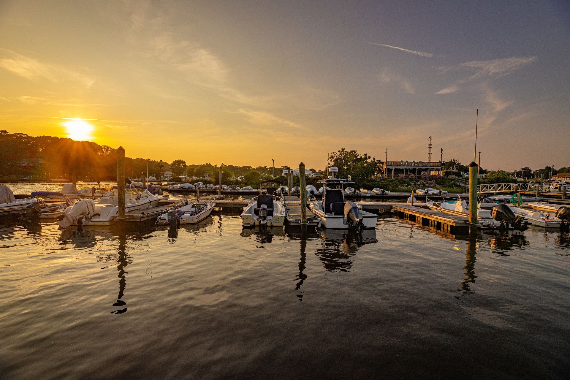 The sun is setting over a marina filled with boats.