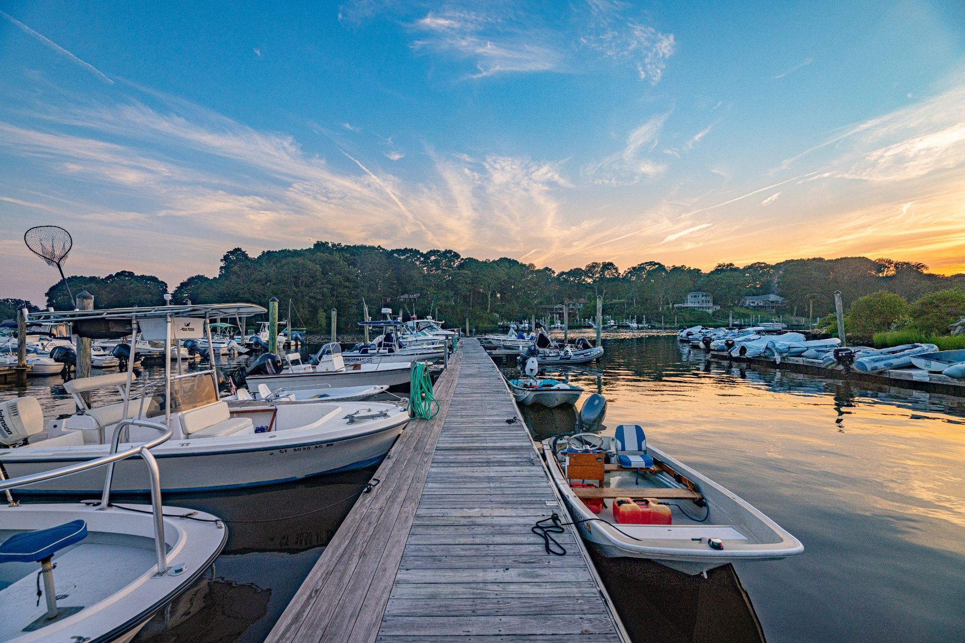 A dock filled with boats and a sunset in the background.