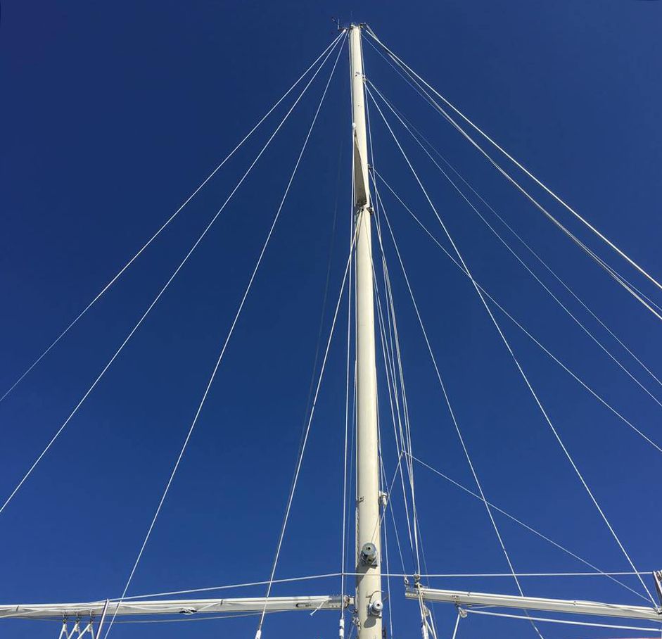 Looking up at the mast of a sailboat against a blue sky
