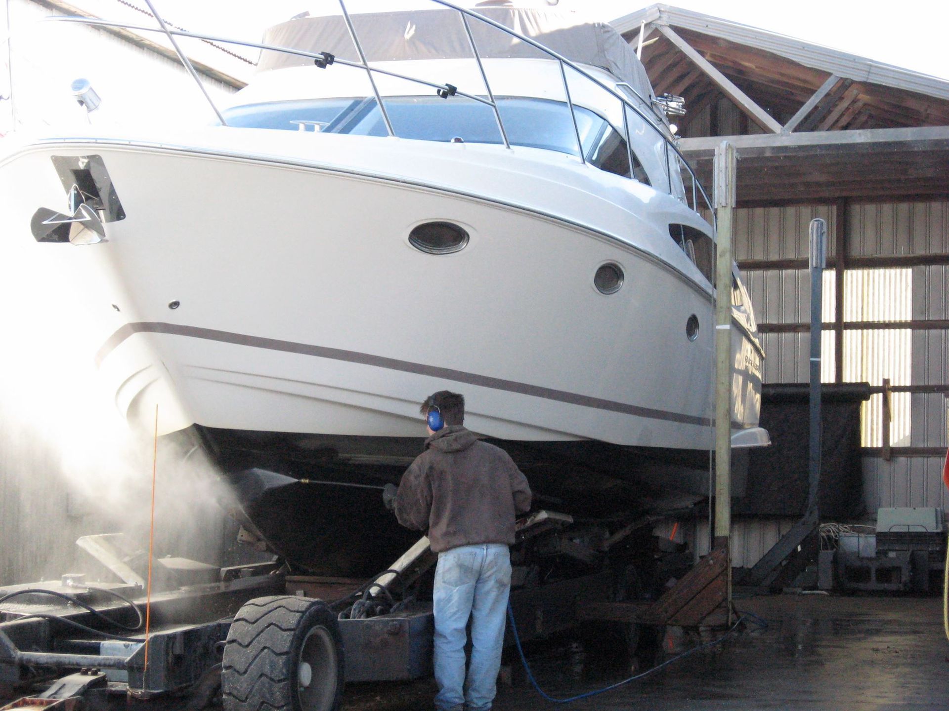 A man is standing in front of a large white boat