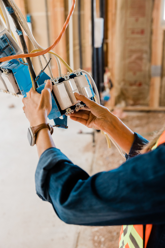 A person is working on electrical wires in a building.