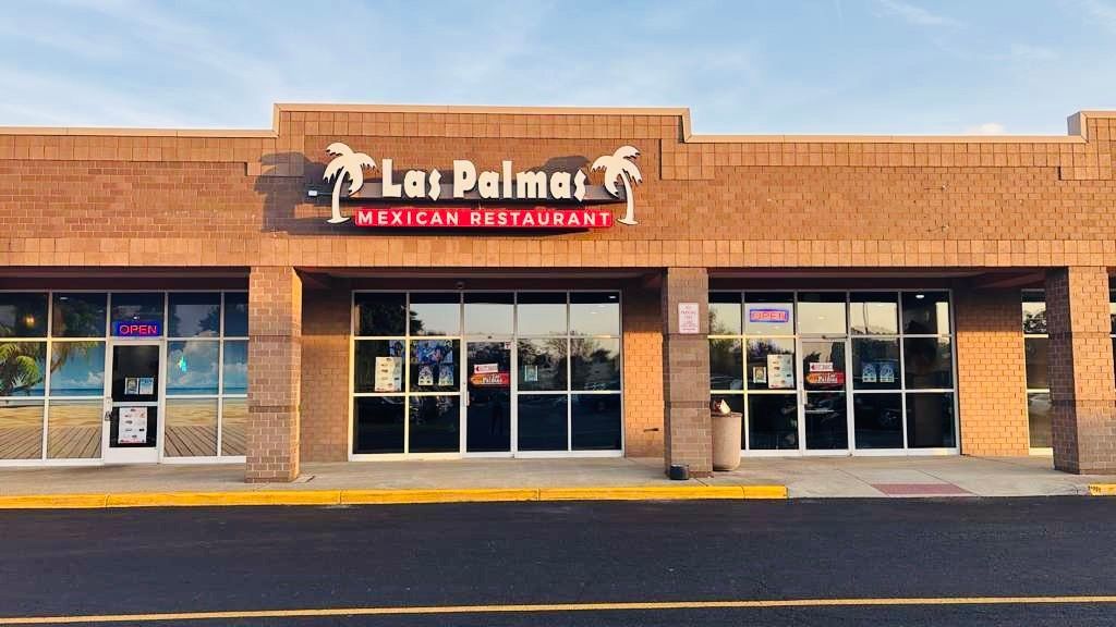 Restaurant exterior with stone facade, string lights, and street lamps.