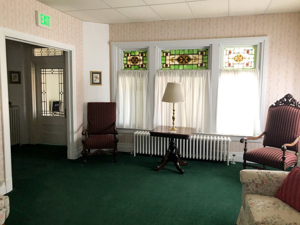 A living room with a table and chairs and a stained glass window