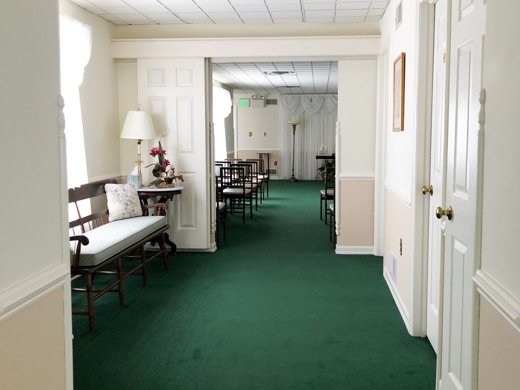 A long hallway with green carpet and white walls