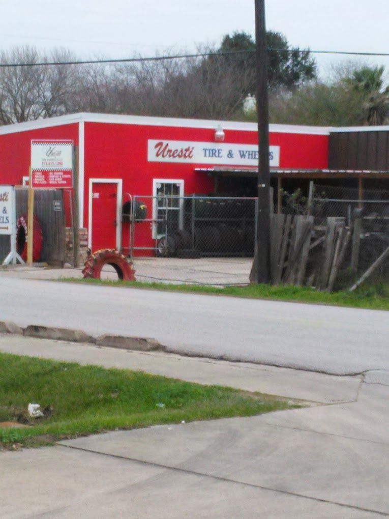 A red building with a sign that says ' trestle tire & wheel ' on it