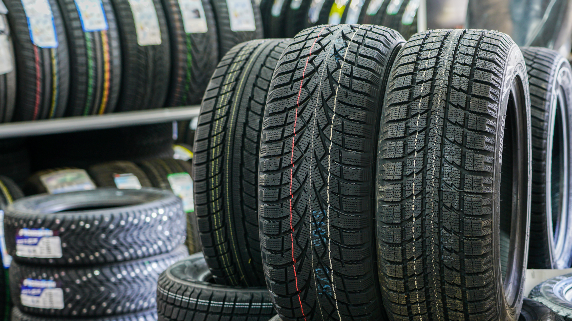 A bunch of tires are stacked on top of each other in a store.