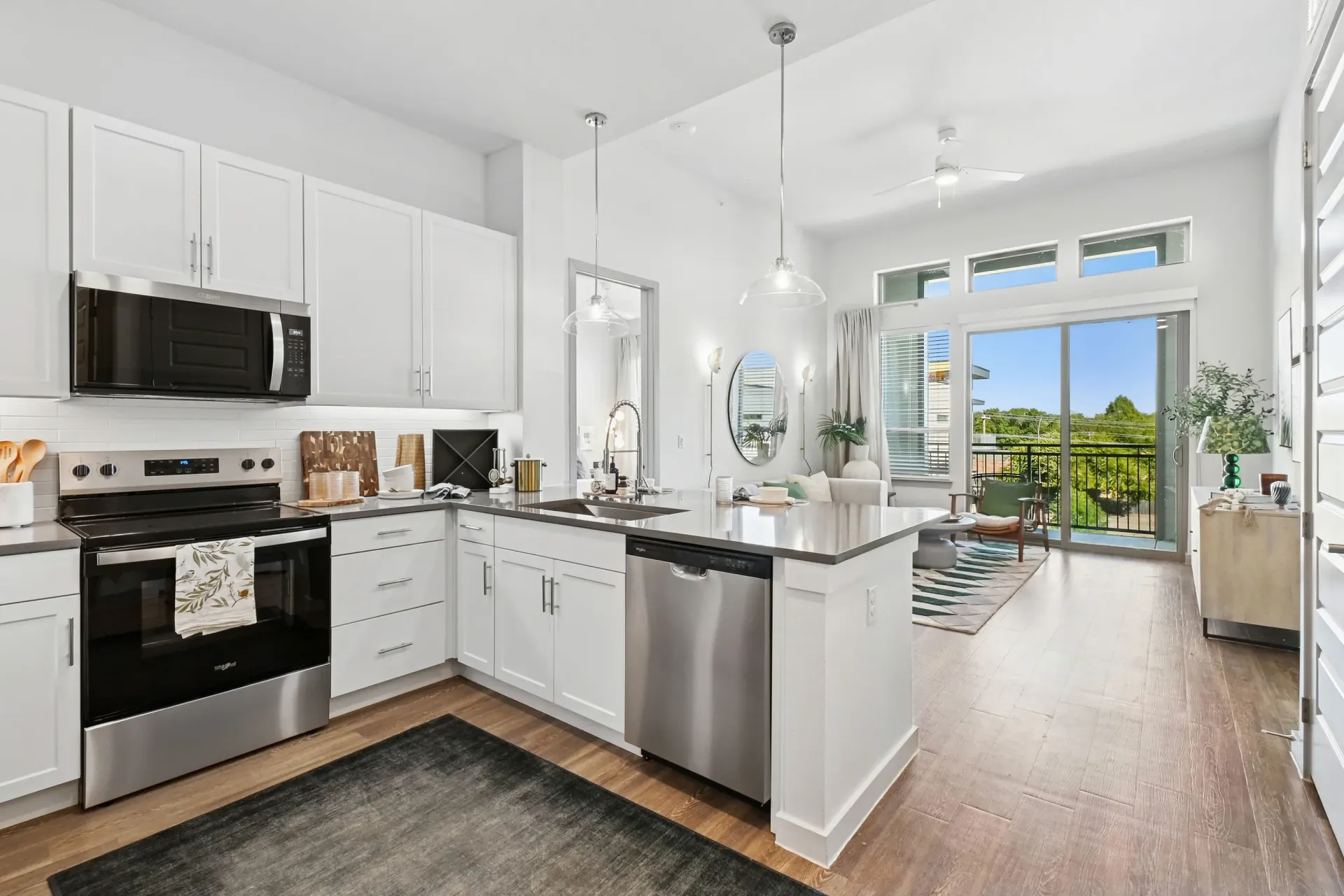 Open-concept kitchen with white cabinets, stainless steel appliances, and a large island.