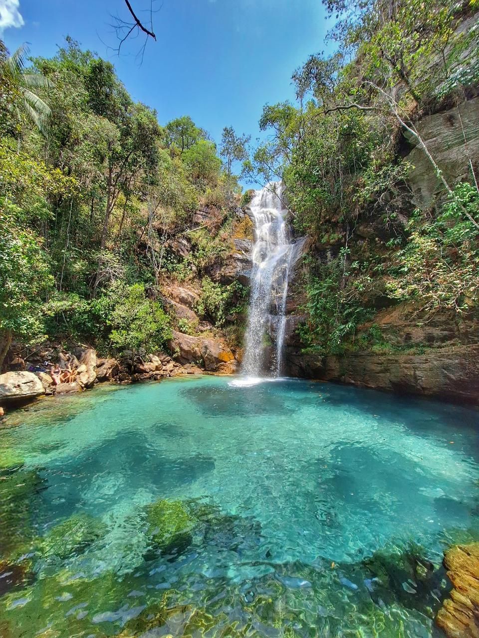 Montanhas cobertas de vegetação seca sob um céu azul nublado.