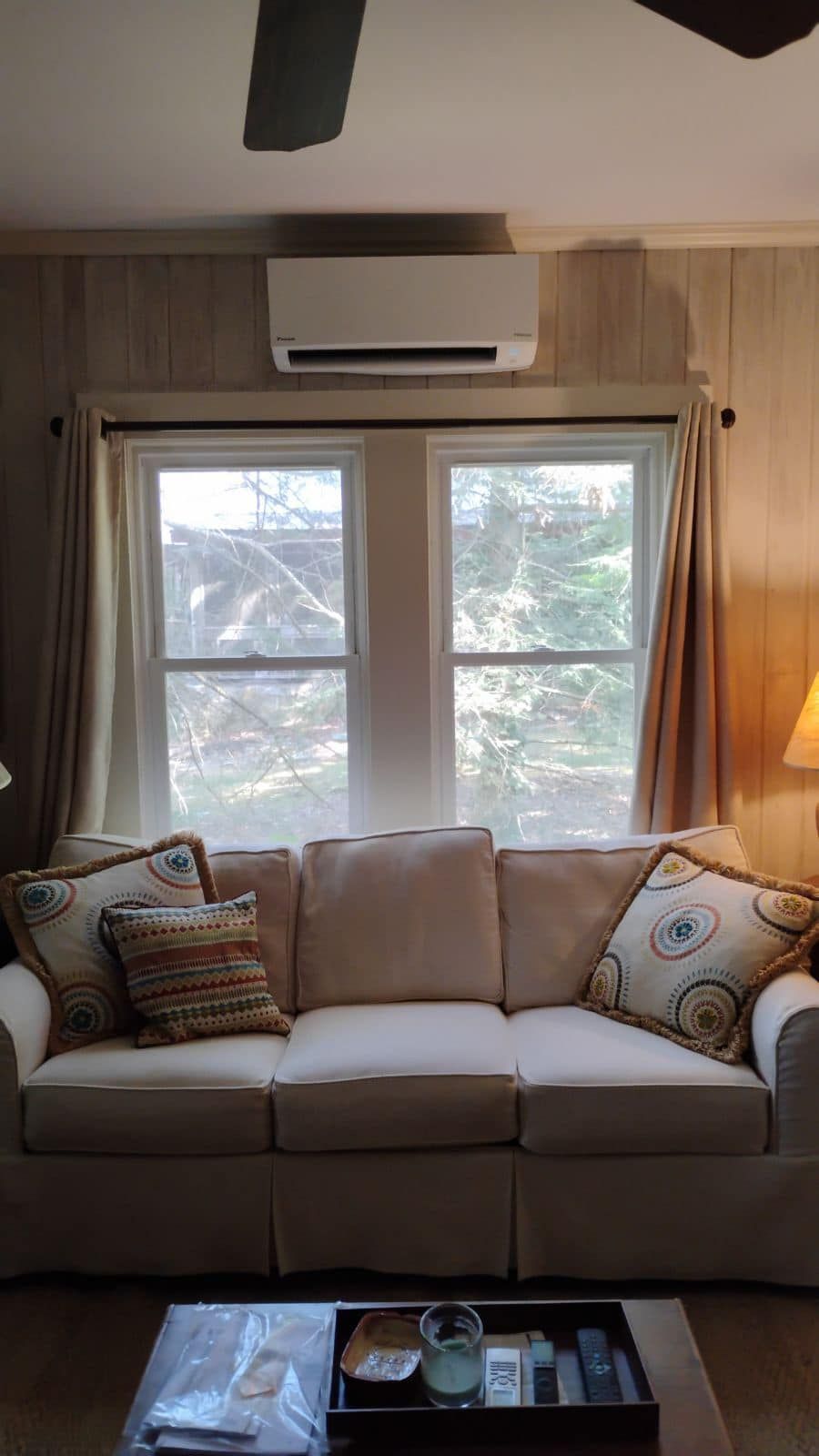 A living room with a couch and a ceiling fan.