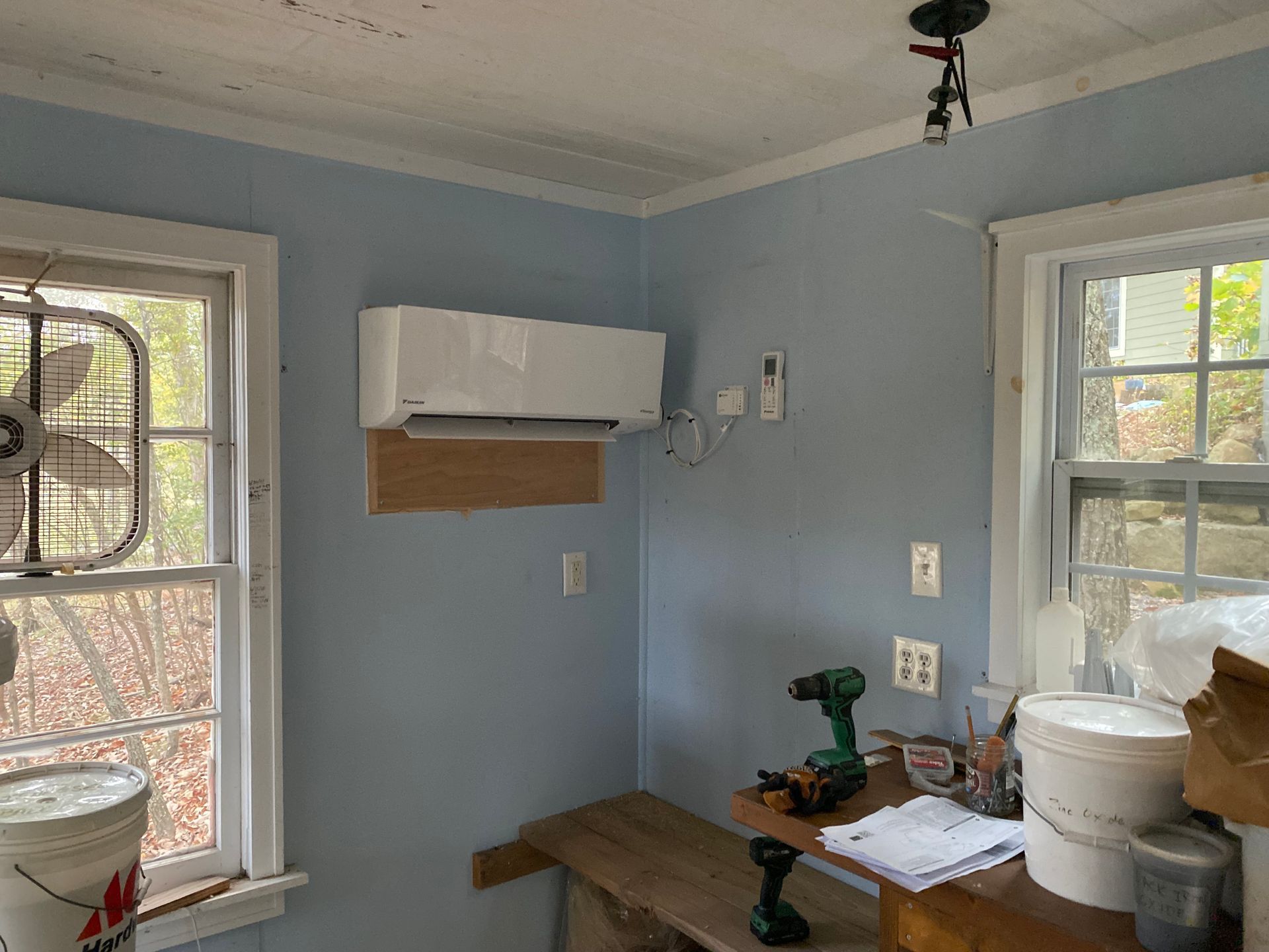 A room with blue walls and a white air conditioner on the wall.