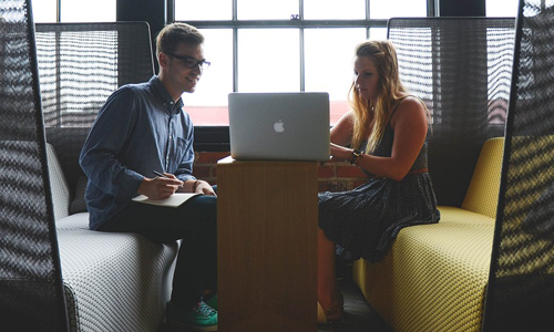 Man and woman sitting at a laptop together