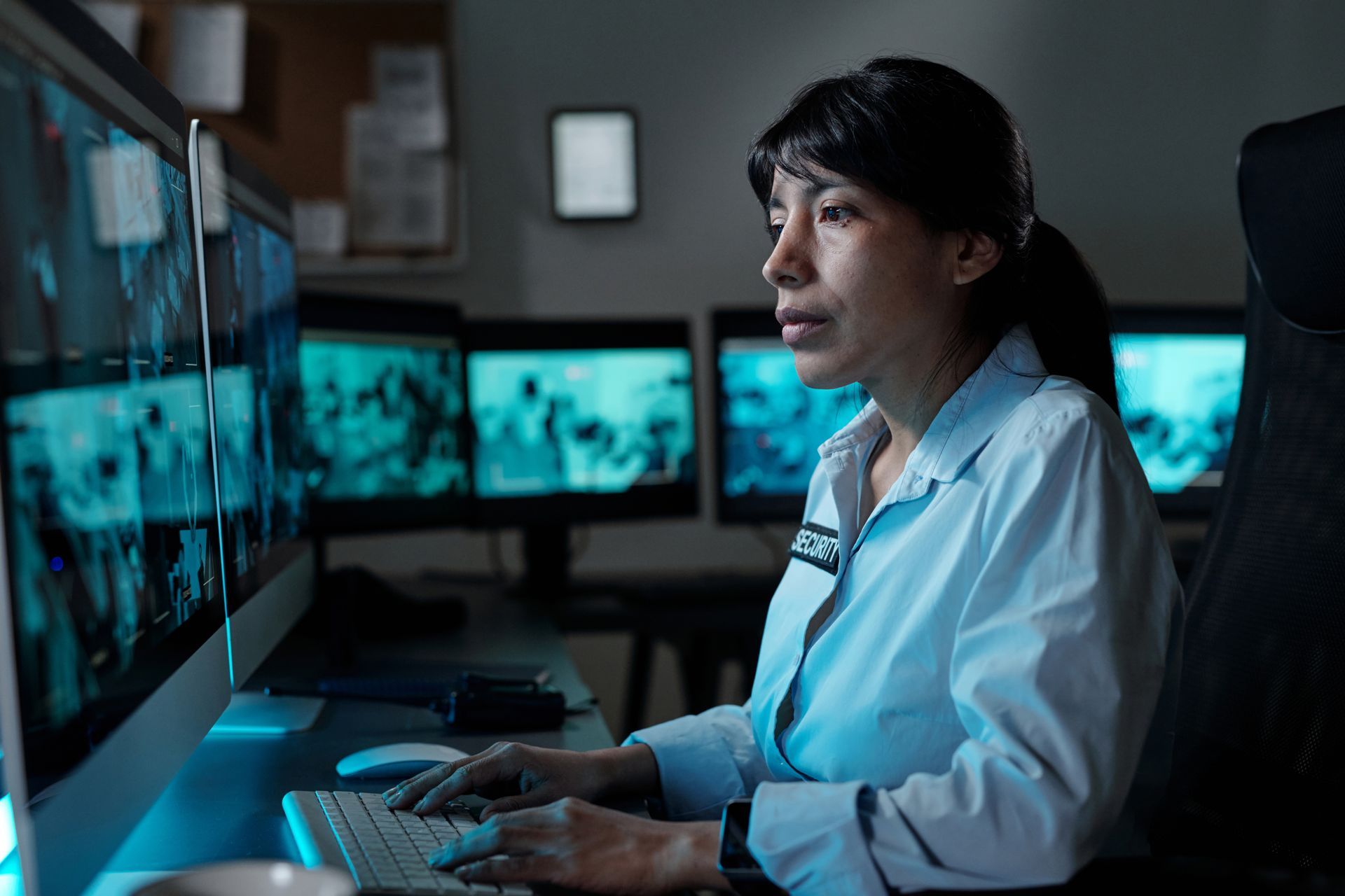 A woman is sitting at a desk in front of a computer monitor.