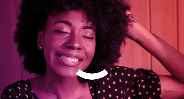 PR SOLUTIONS A woman with an afro is smiling with her eyes closed.