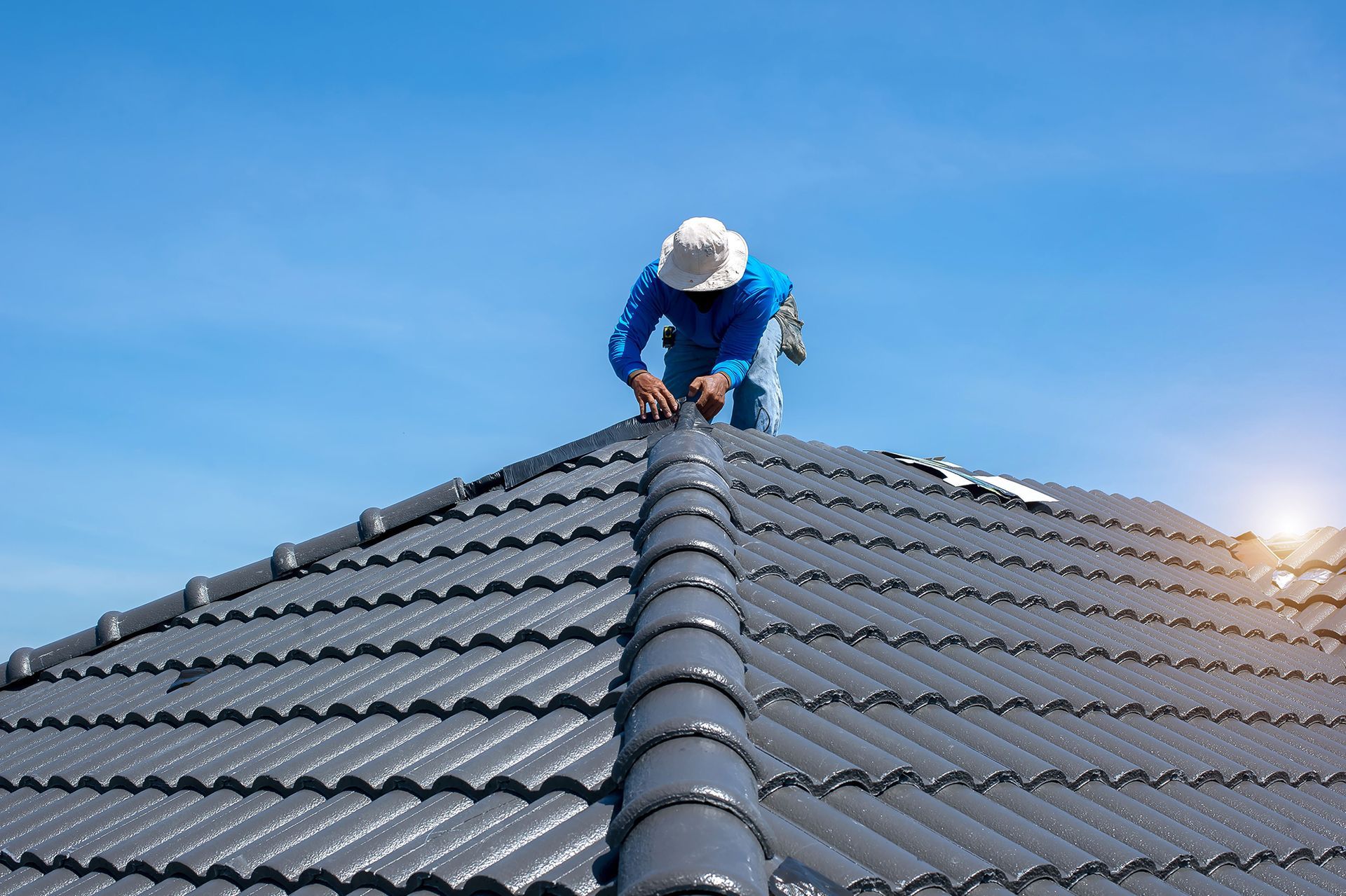 A man is working on the roof of a house.