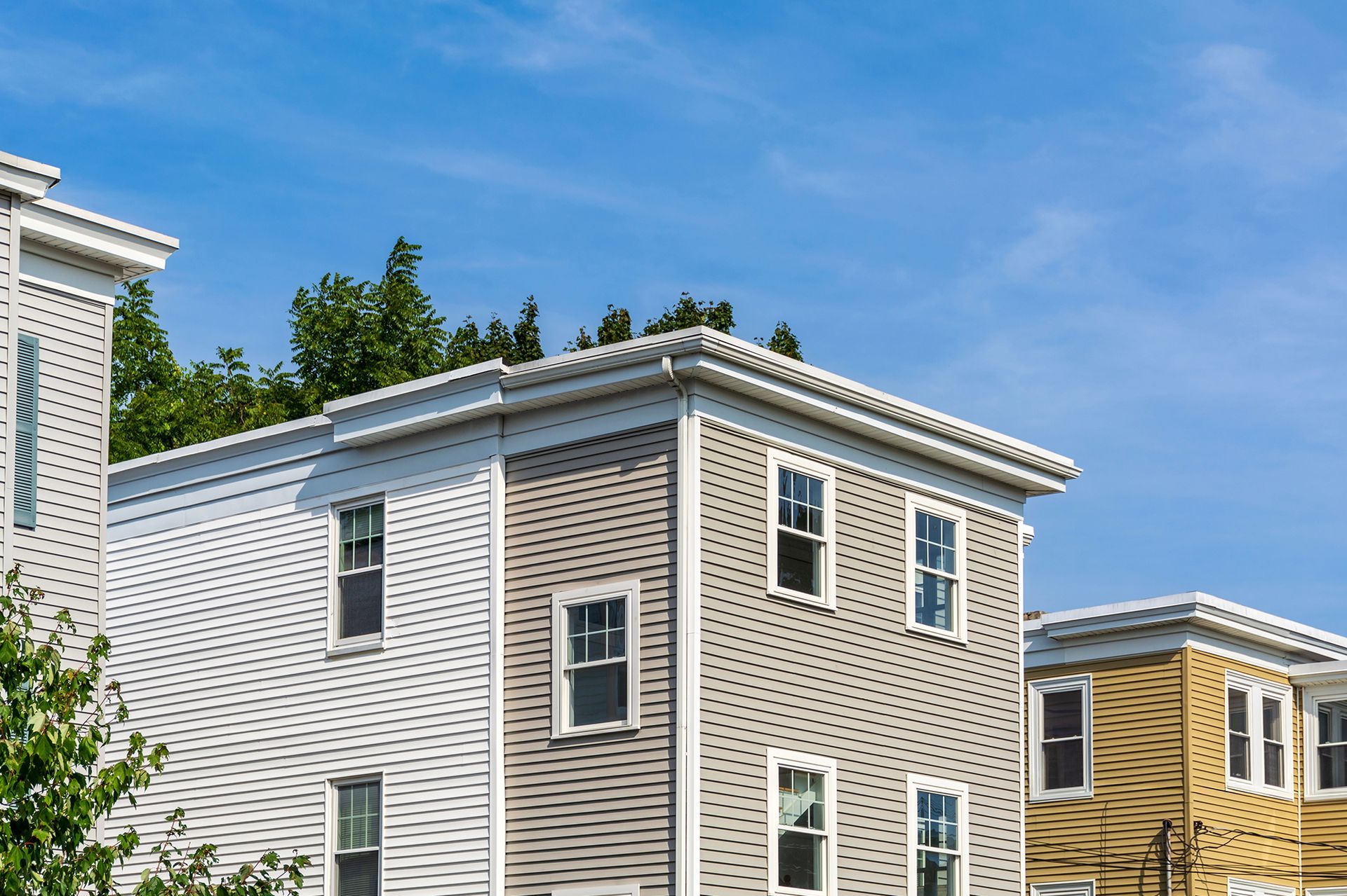 A row of houses with a blue sky in the background.