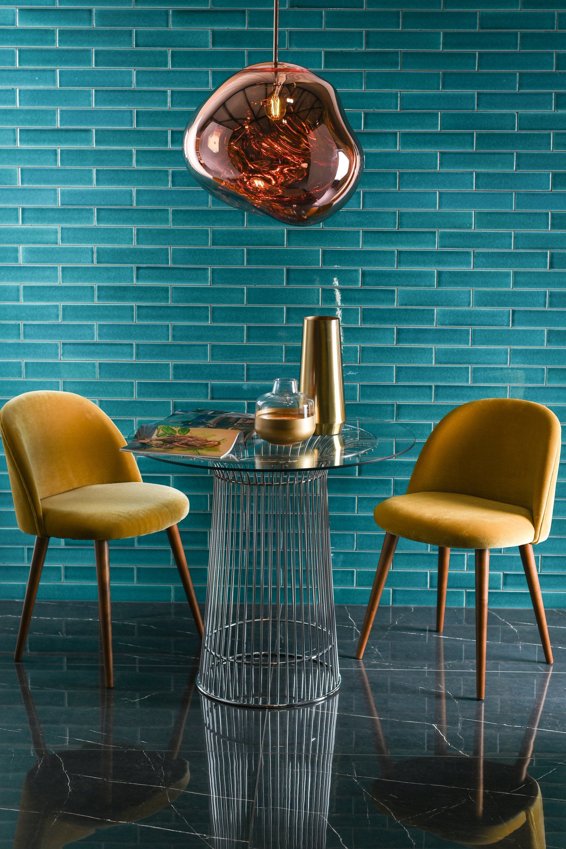 A beautifully tiled wall with two chairs near to it
