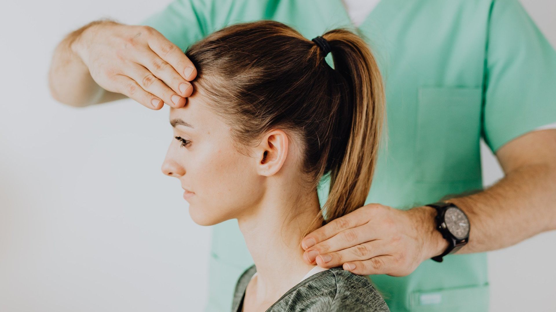 Een vrouw krijgt een nekmassage van een dokter.