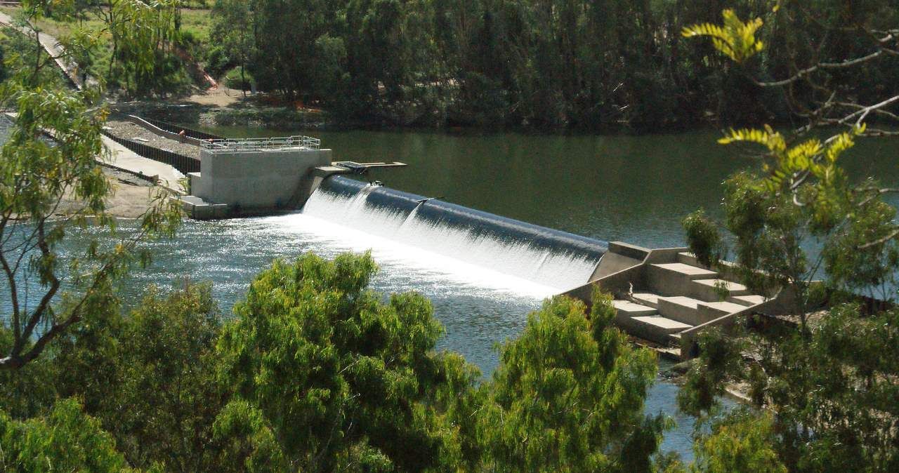 Scenic River Flowing Over A Small Dam — Experienced Builder in Collinsville, QLD