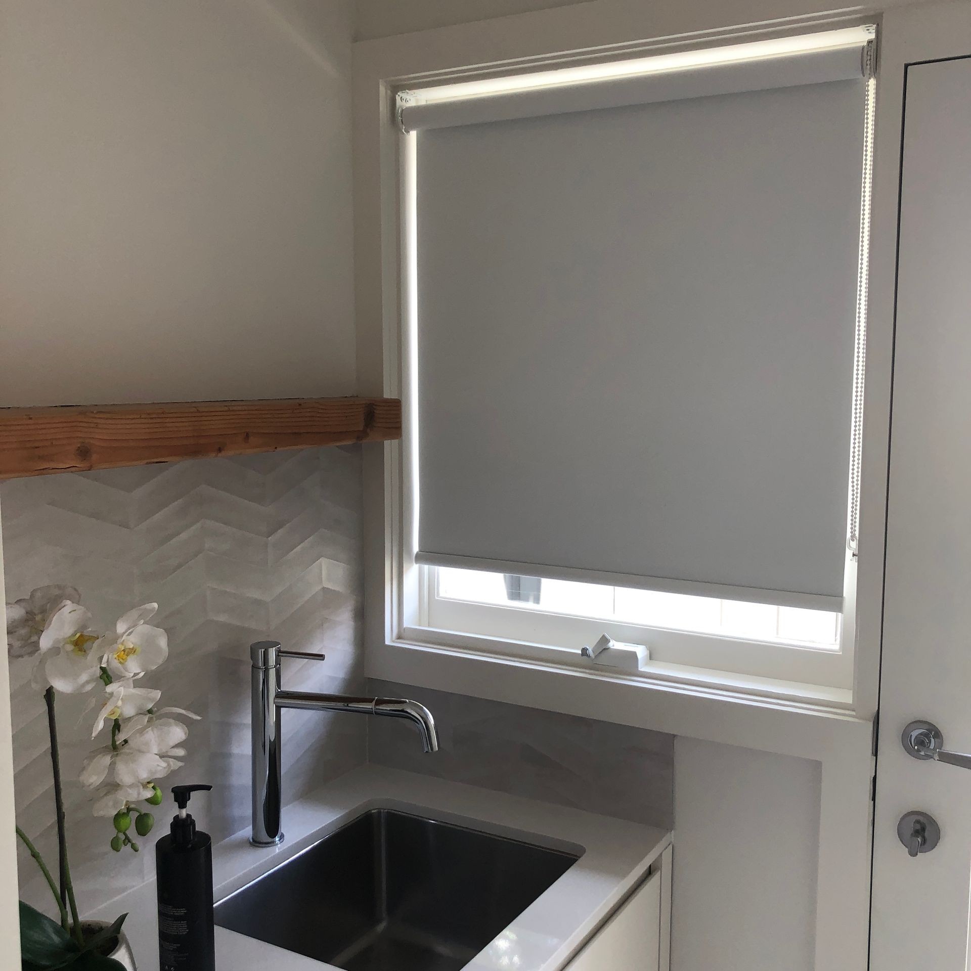 Bathroom Sink With Window and Closed Gray Roller Blind — My Timber Flooring Blinds & Shutters in Erina, NSW