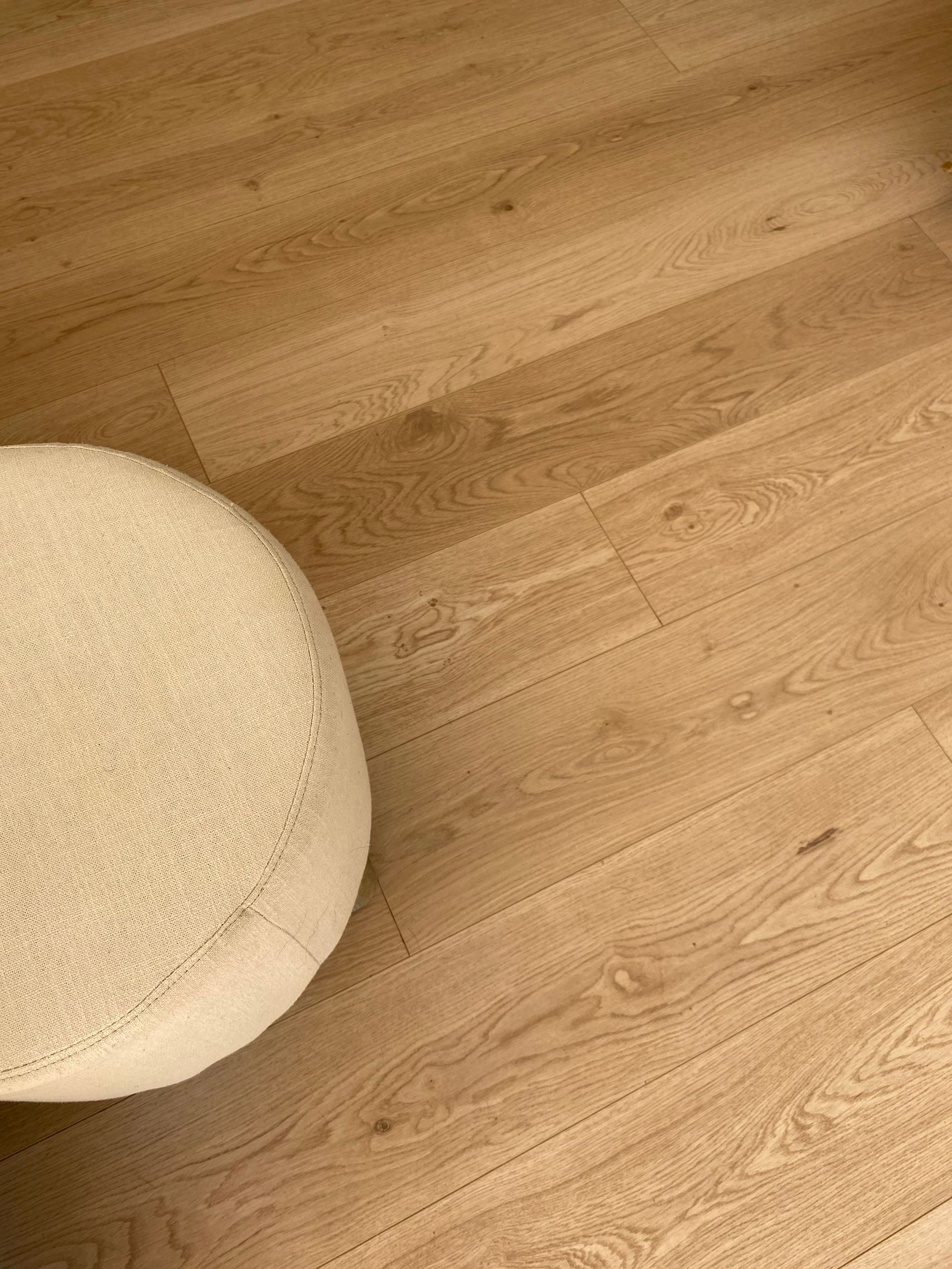Off White Round Ottoman on Light Brown Wood-grain Flooring — My Timber Flooring Blinds & Shutters in Erina, NSW