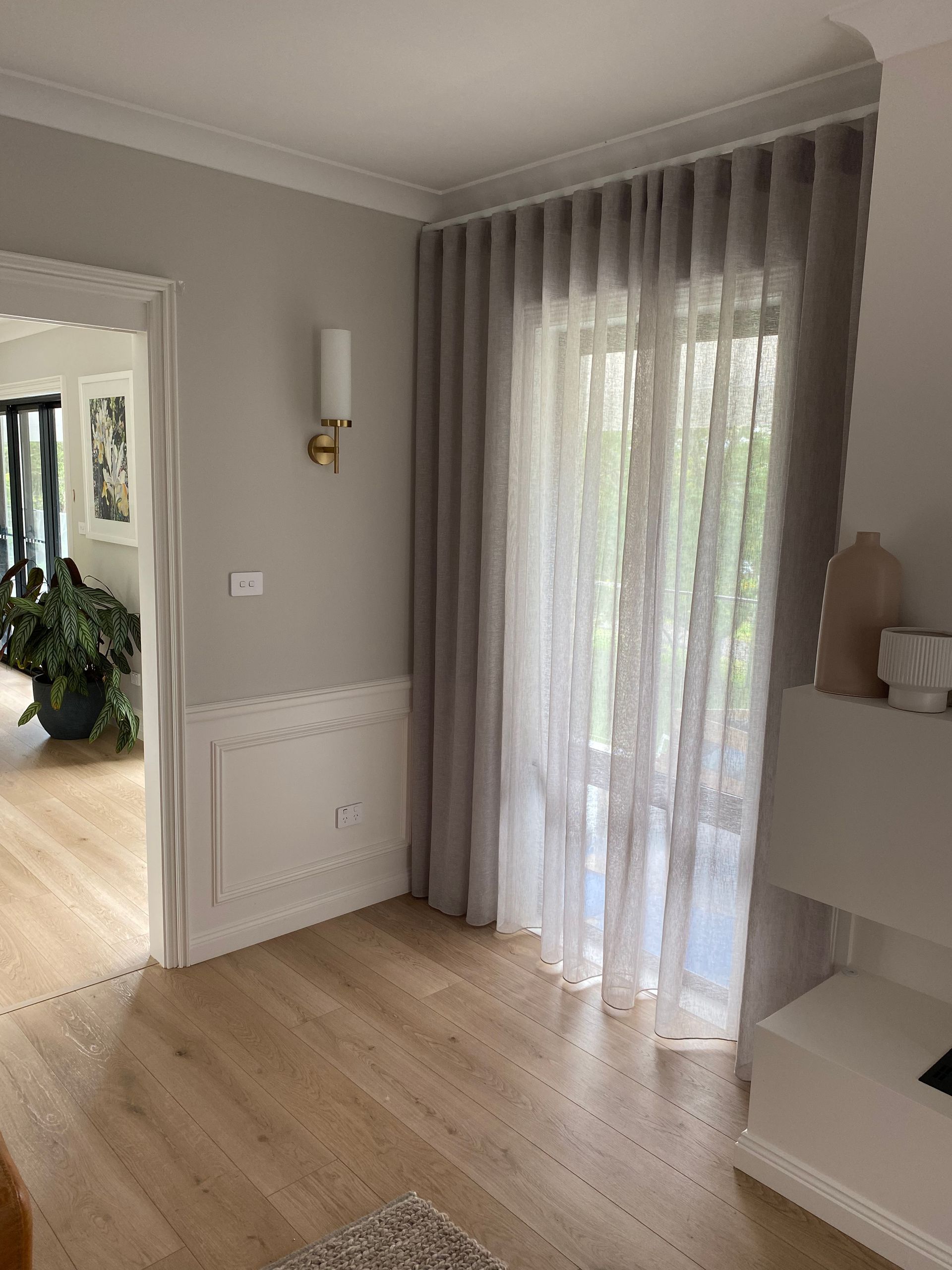 A Corner of a Room With Light Gray Walls, Light Wood Floors and Sheer Curtains — My Timber Flooring Blinds & Shutters in Erina, NSW