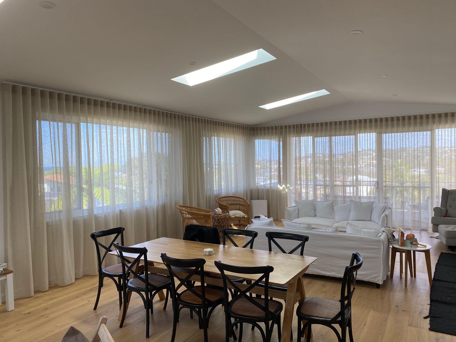 Dining Room With Wood Table and Chairs, Sheer Curtains, Skylights, and a Couch — My Timber Flooring Blinds & Shutters in Erina, NSW