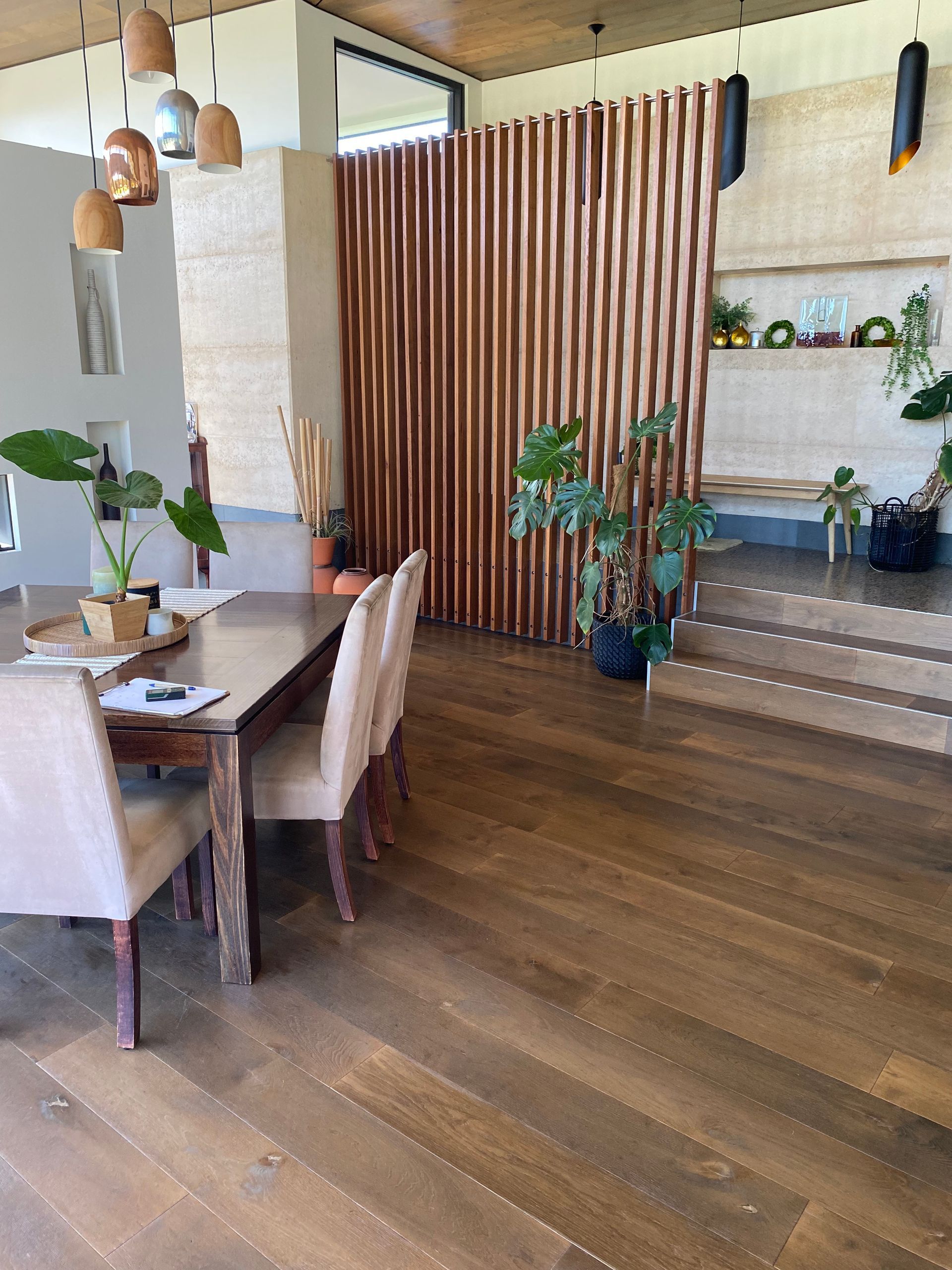 Dining Room With Wooden Floors, a Long Table and Beige Chairs, and a Vertical Wooden Wall — My Timber Flooring Blinds & Shutters in Erina, NSW