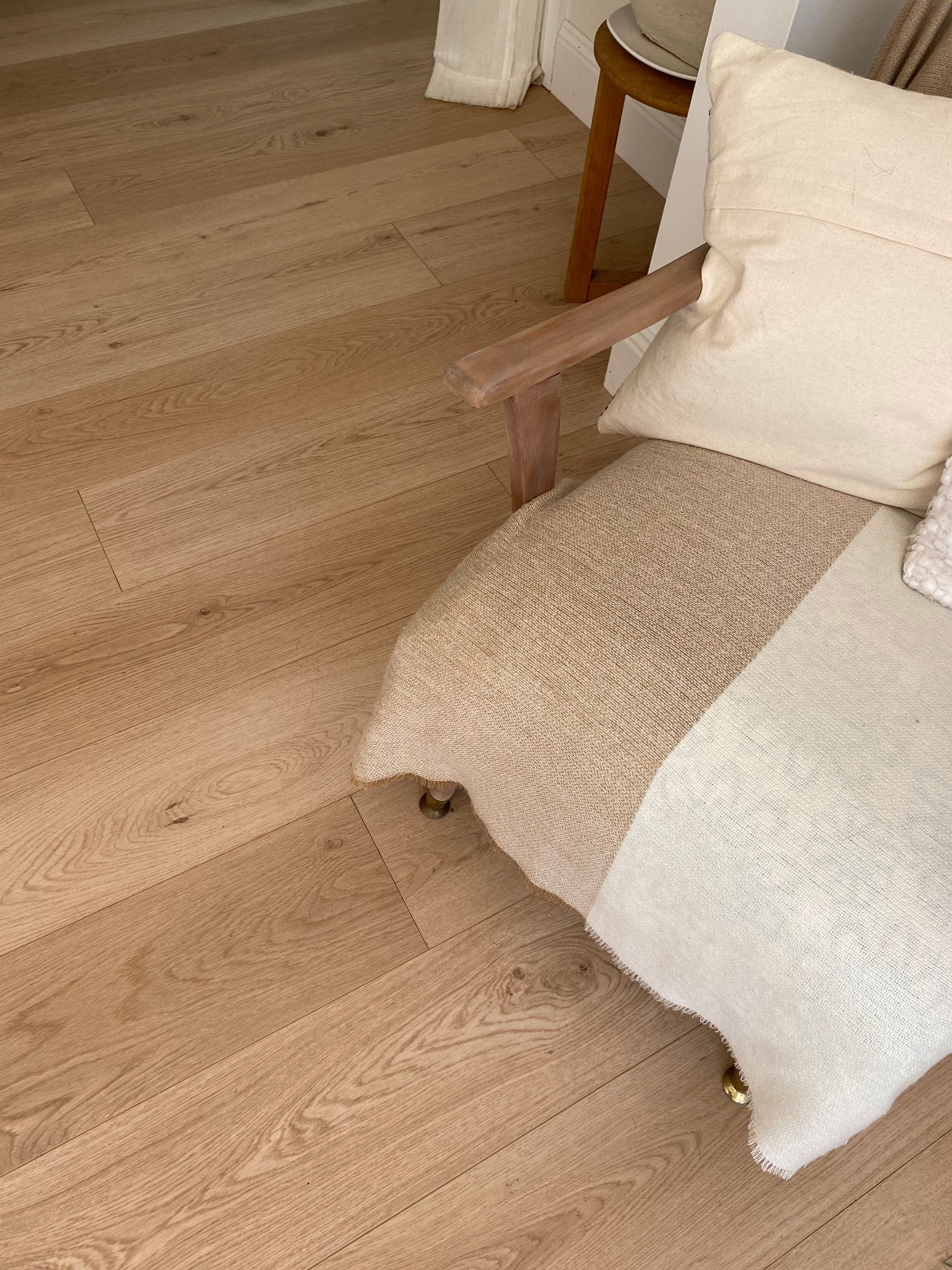 Light Wood-floored Room With a Beige Chair, White Pillows, and a Cozy Blanket — My Timber Flooring Blinds & Shutters in Erina, NSW