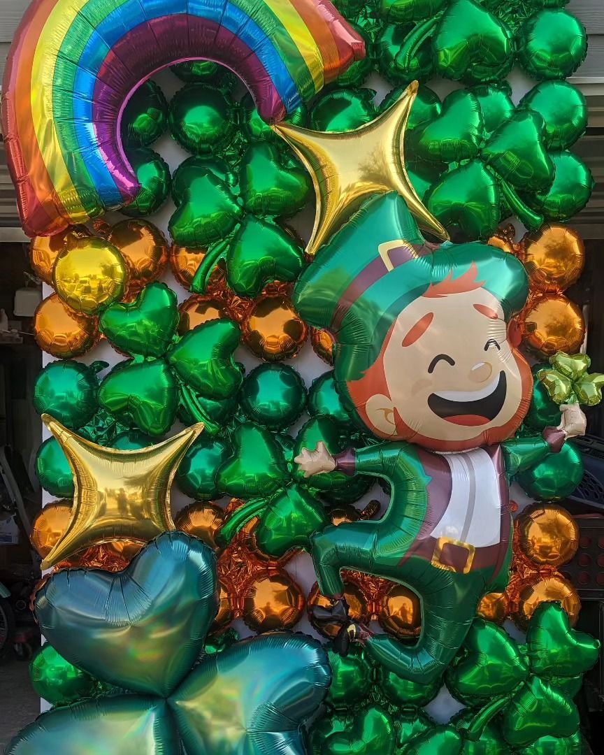 St. Patrick's Day balloon display: Rainbow, gold stars, leprechaun, green shamrocks, gold and green balloons.
