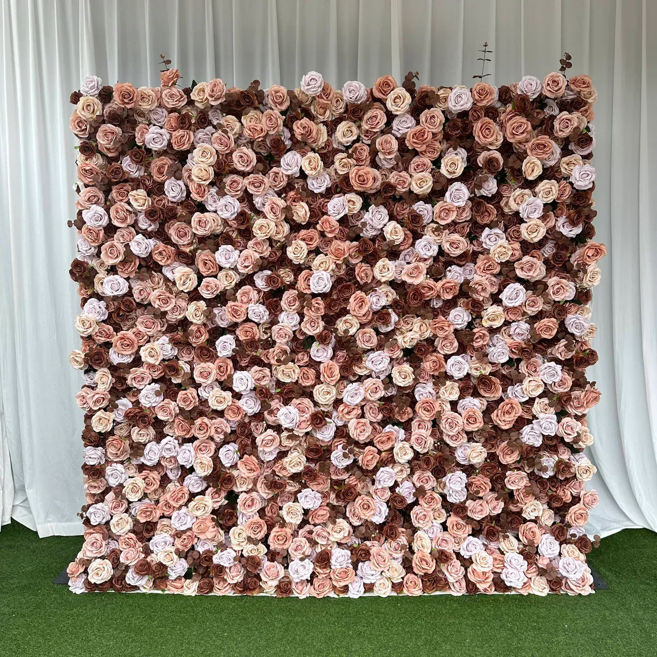 Flower wall backdrop with roses in shades of brown, pink and white.