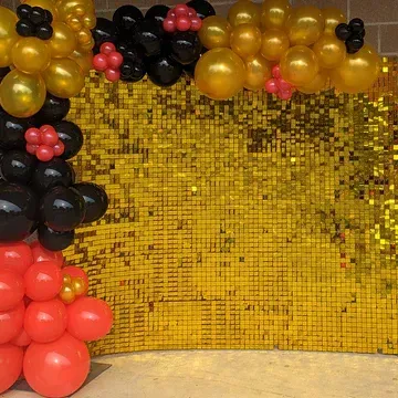 Golden sequin backdrop with balloon arch in black, gold, and red.