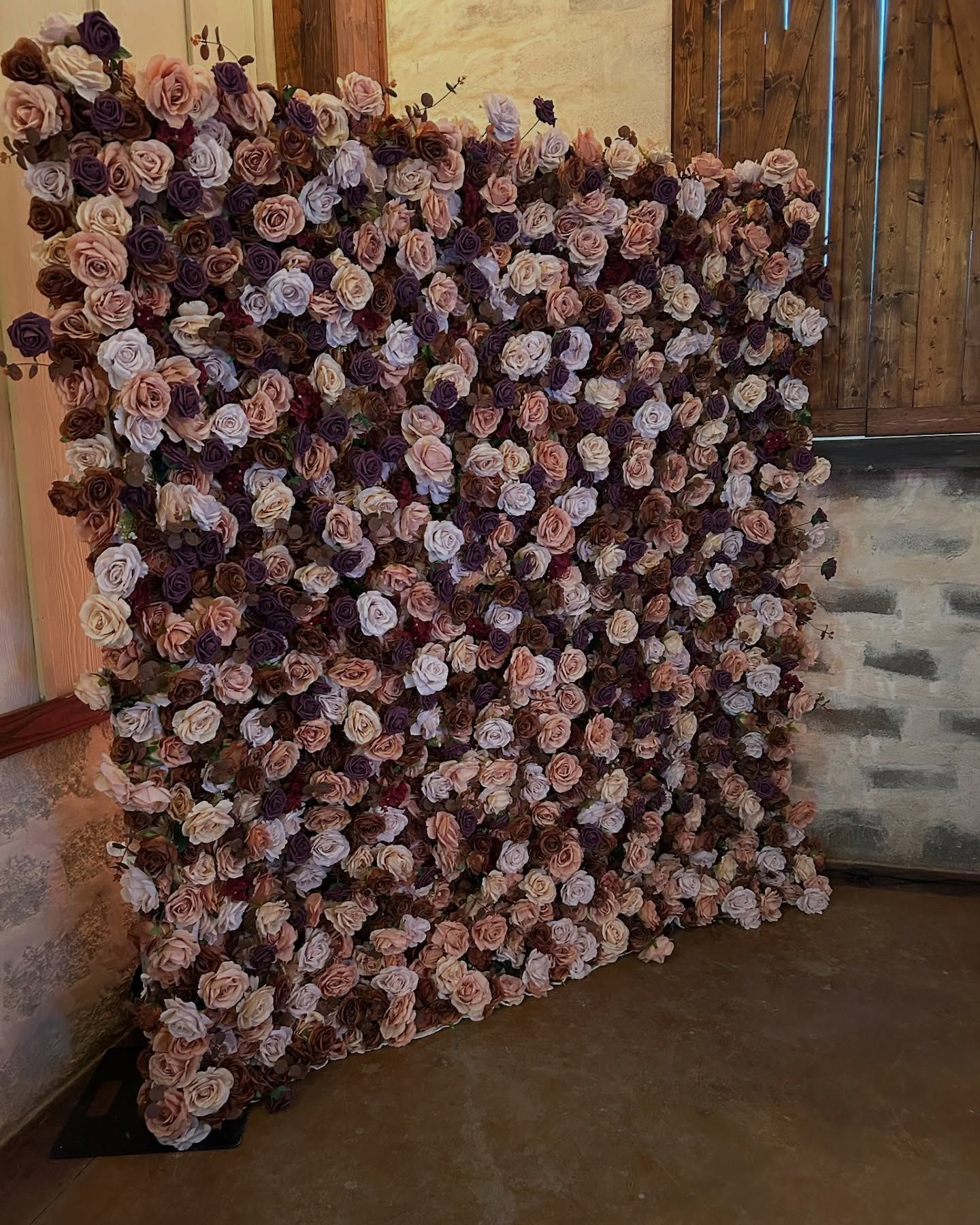 Flower wall of pink and purple roses, indoors.