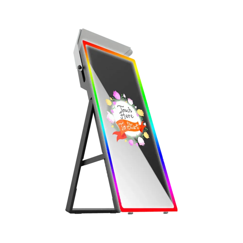 A standing photo booth with a reflective screen, rainbow LED trim, and a black stand.