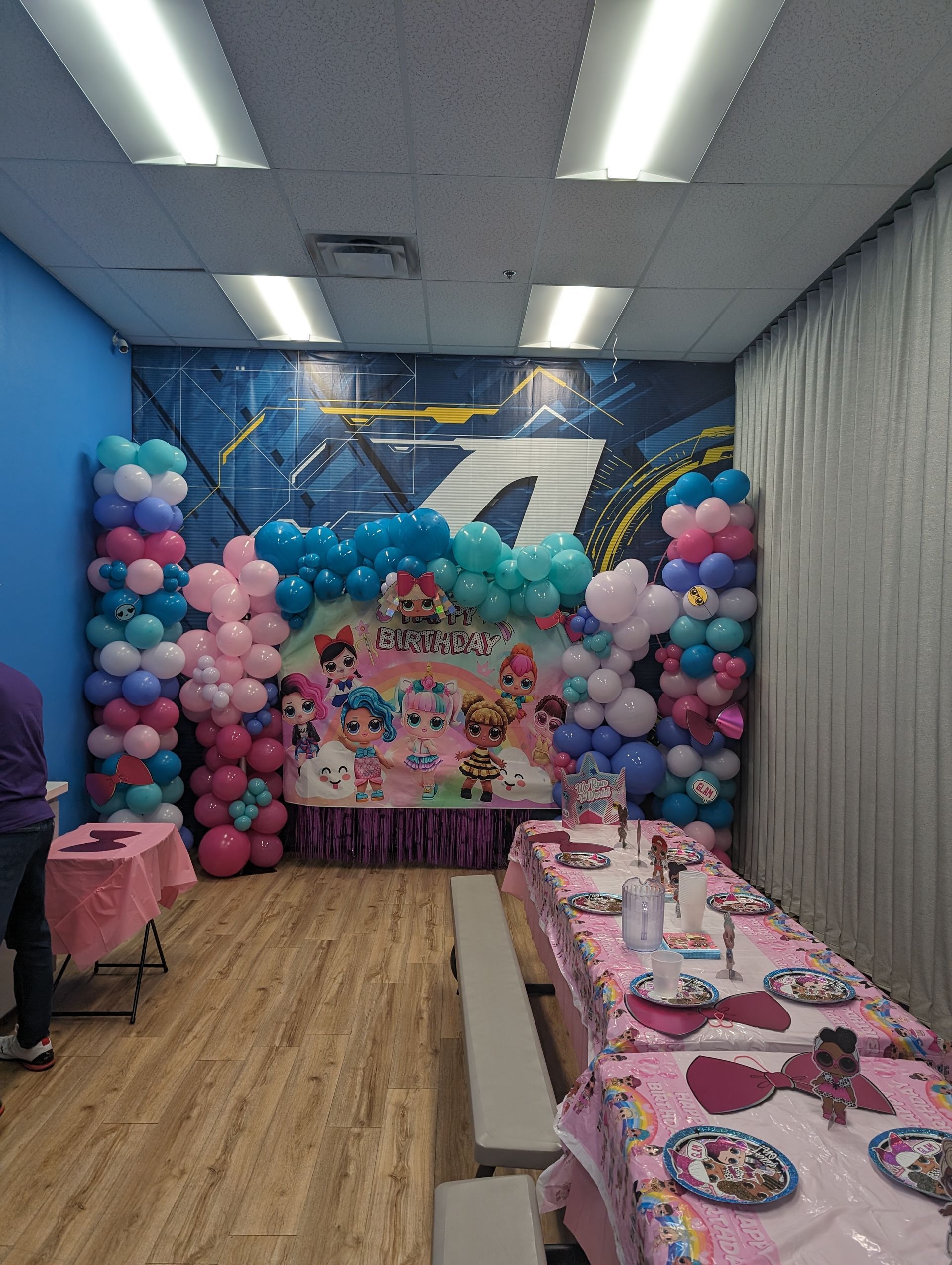 Birthday party scene: Shimmer and Shine backdrop, balloon decorations in pinks, blues, and white. Tables set for guests.