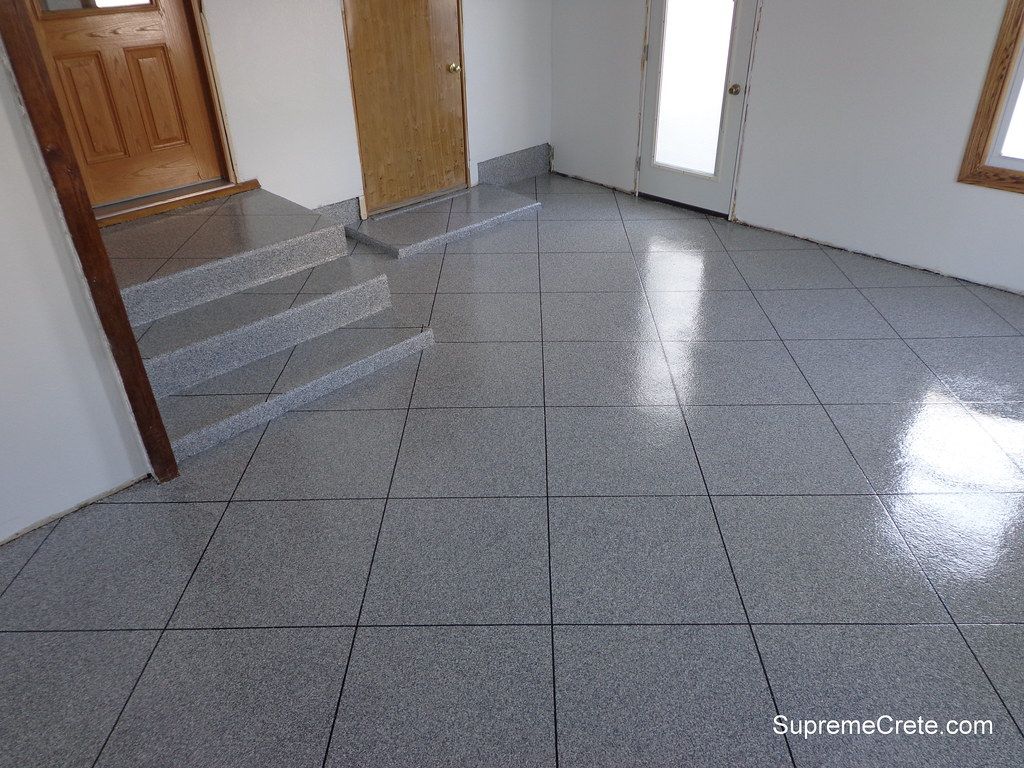 Grey flake epoxy coating on a residential entryway floor and stairs.