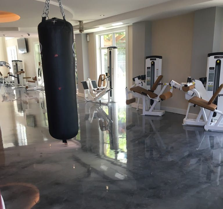 Commercial gym facility featuring high-shine grey epoxy floor coating.