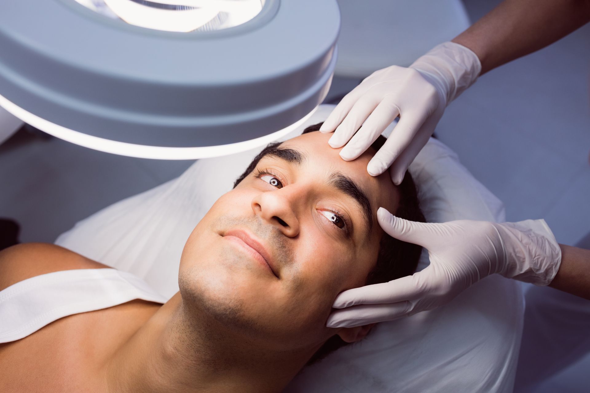 a man is getting his face examined by a doctor