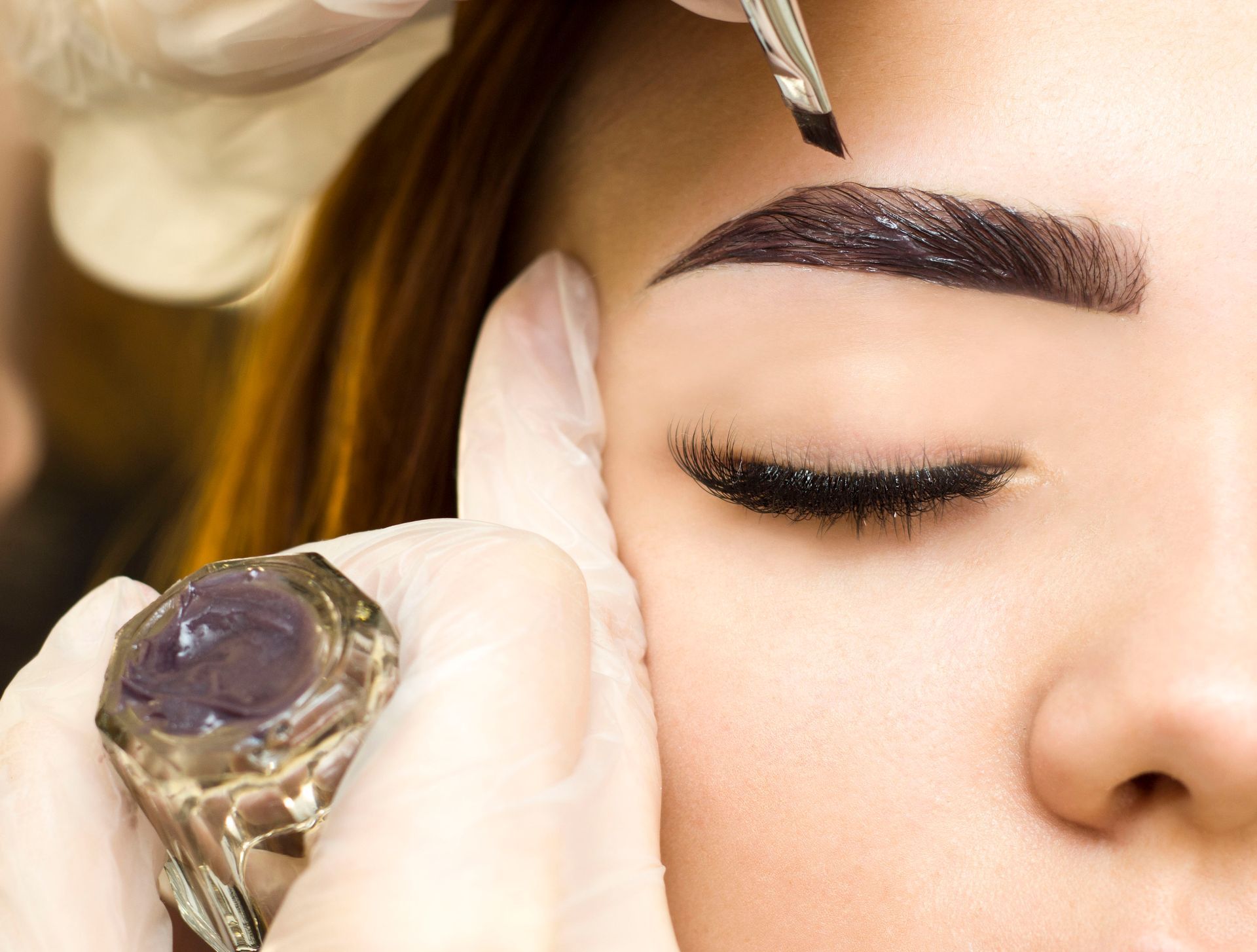 woman getting an eyebrow henna treatment
