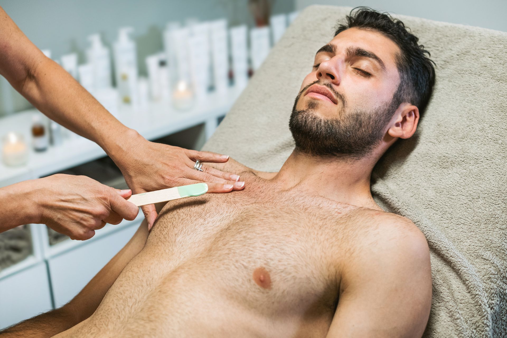 a man has his chest waxed in a beauty salon
