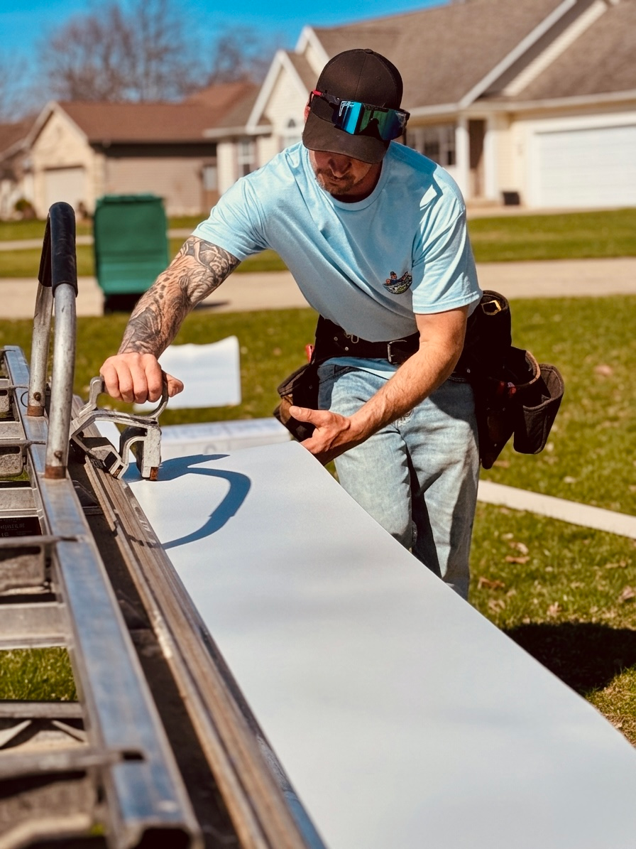 Worker smoothing concrete sidewalk with a trowel outdoors on a sunny day