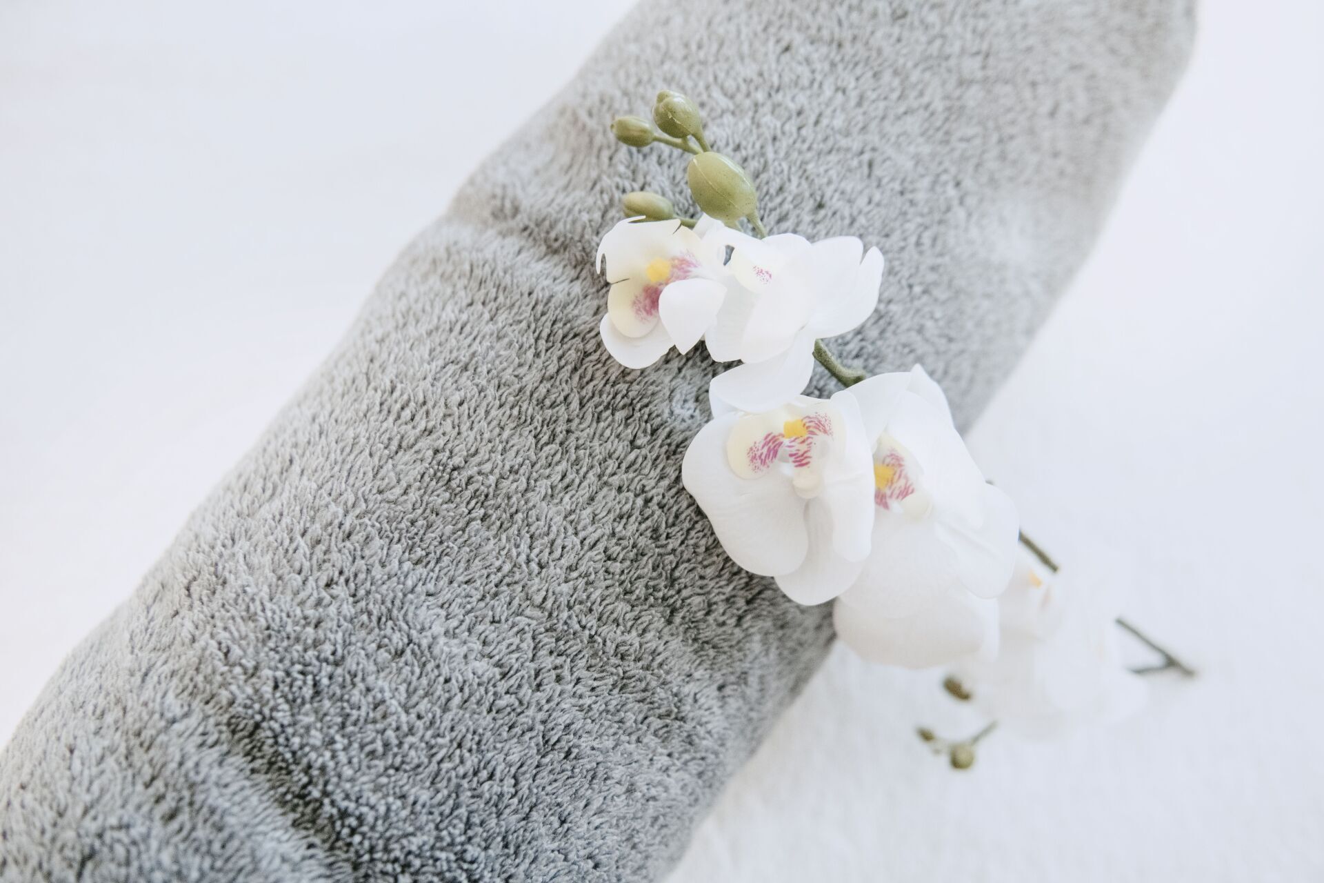 Eine Nahaufnahme eines Handtuchs mit weißen Blumen darauf.