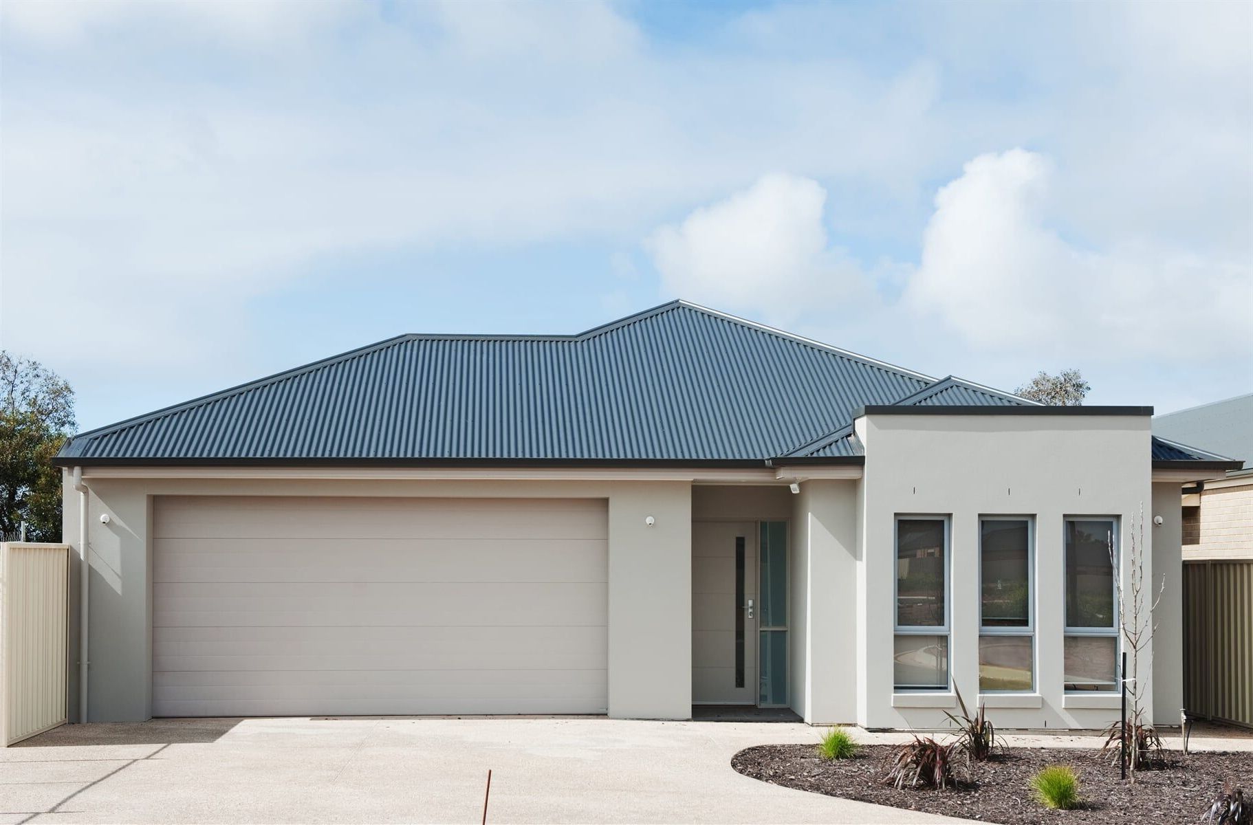 A White House With a Garage Door — Gem Garage Doors in Coffs Harbour, NSW
