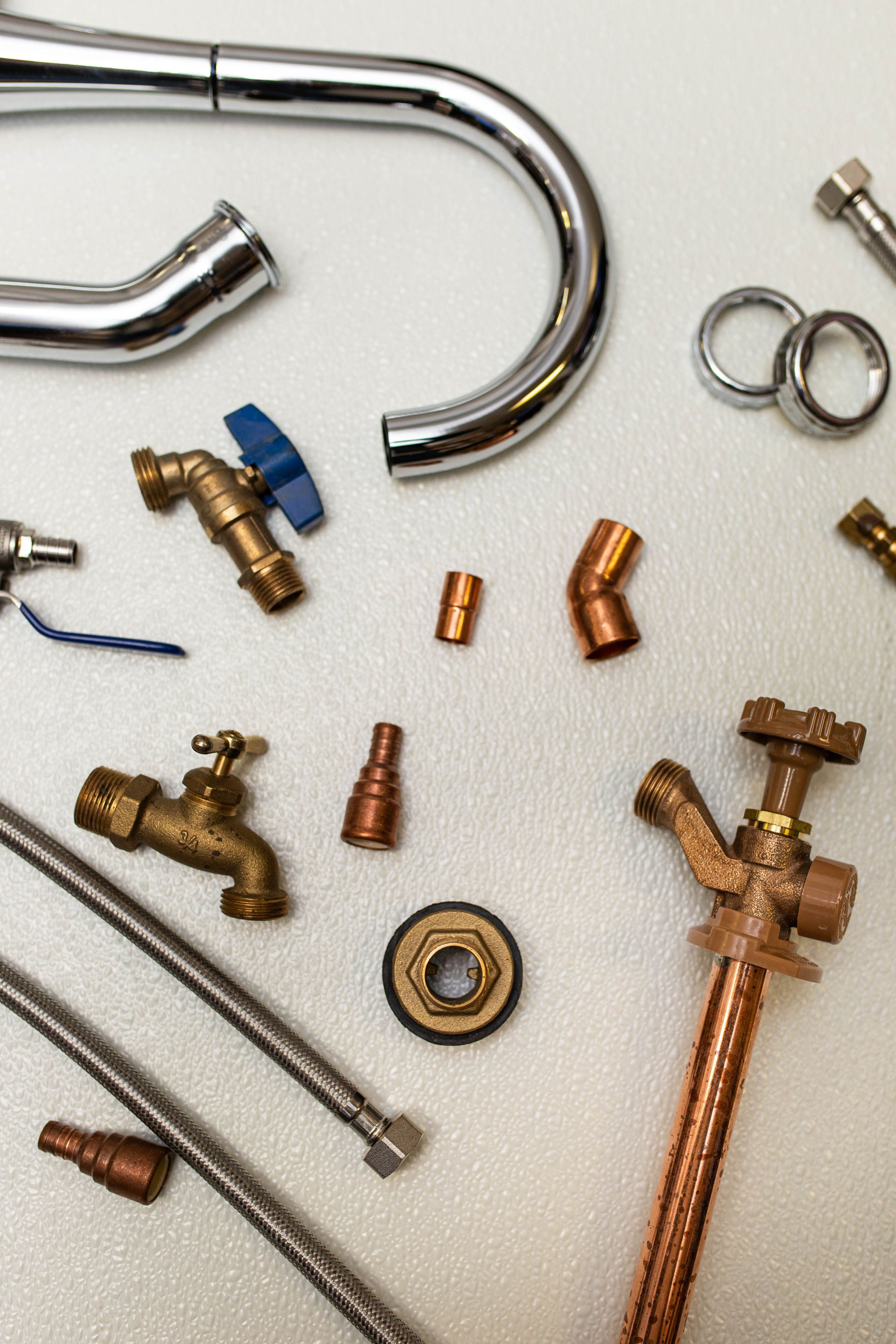 Flat lay picture with plumbing parts and bolts, hoses, screws