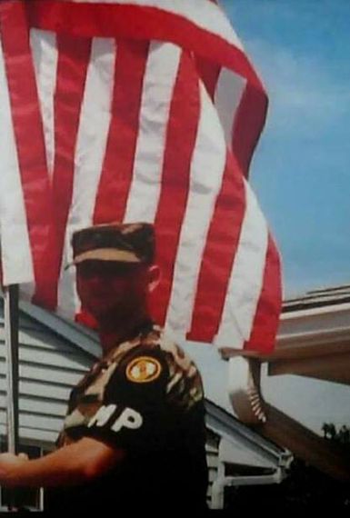JP Quinn in uniform holding an American Flag