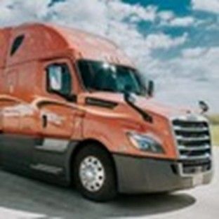 An orange trailer under a sunny blue sky with white clouds in the background