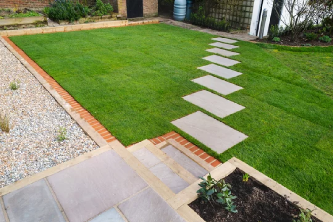 A lush green lawn with a walkway in the middle of it.