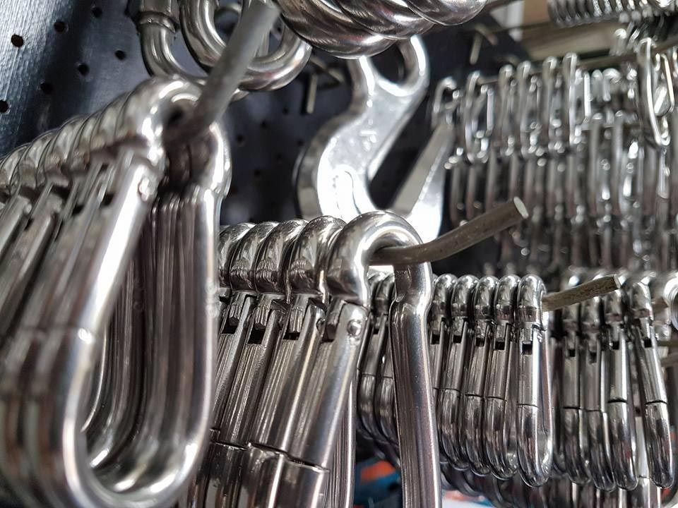 A Bunch of Stainless Steel Hooks Are Hanging on A Wall — Border Bolts & Fasteners in Tweed Heads South, NSW