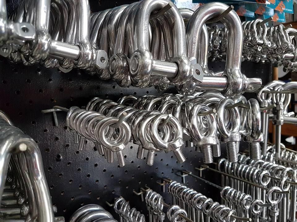 A Bunch of Stainless Steel Hooks Are Hanging on A Rack — Border Bolts & Fasteners in Tweed Heads South, NSW