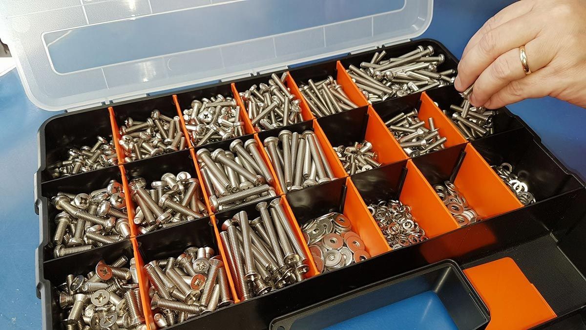 A Person Is Reaching Into a Box of Screws and Nuts — Border Bolts & Fasteners in Tweed Heads South, NSW